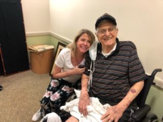 Veteran in a Wheelchair being hugged by a Nurse